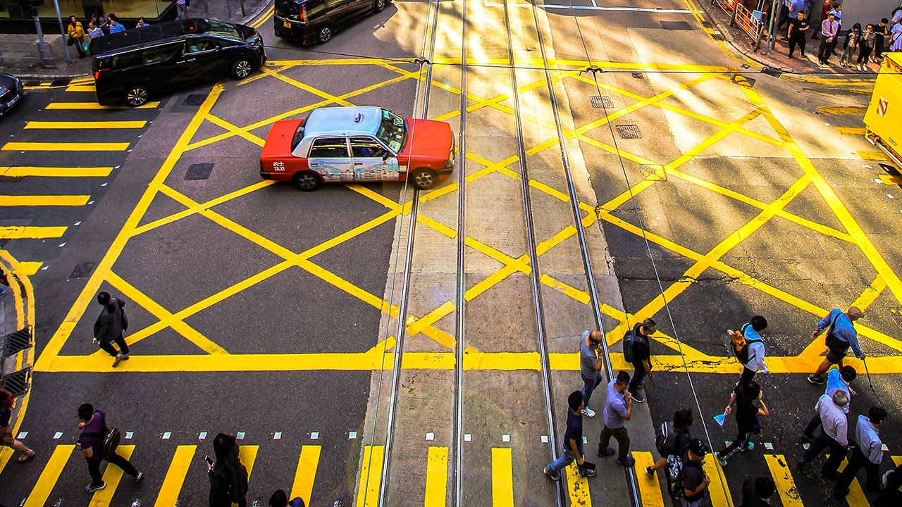 Top view of a busy crossroad with a red taxi in the middle