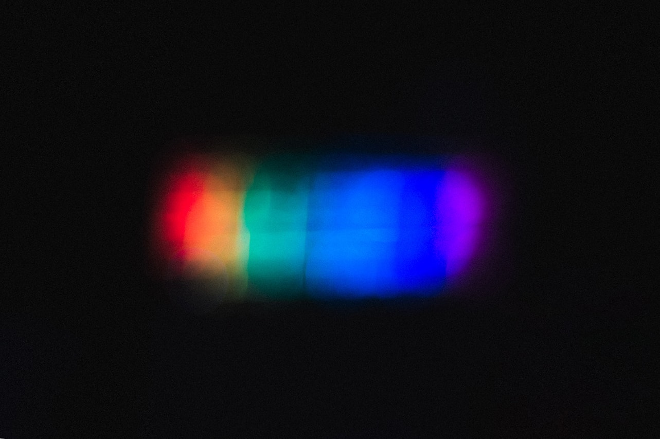 Abstract picture of rainbow colored lighting in a dark room | Photo by Akshar Dave on Unsplash