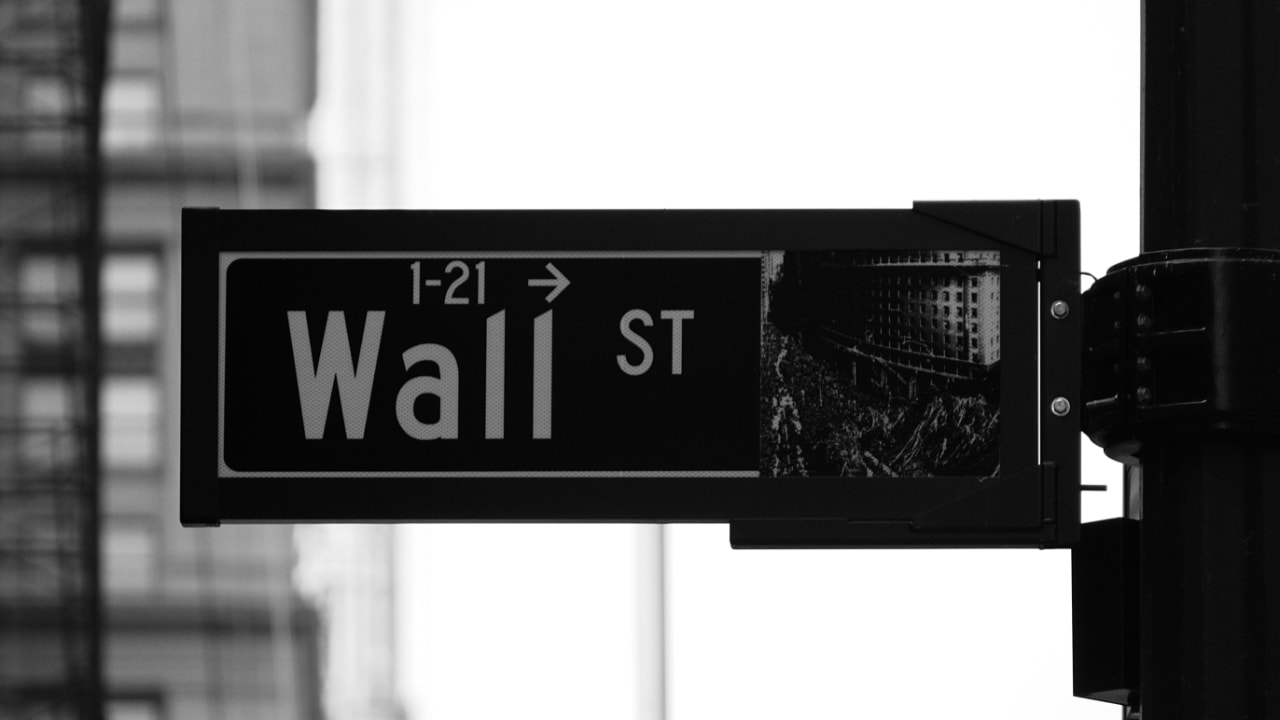 Close-up view of a wayfinding signage showing direction to Wall Street