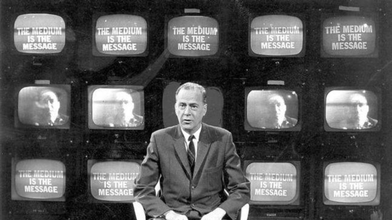 Marshall McLuhan in front of multiple televisions
