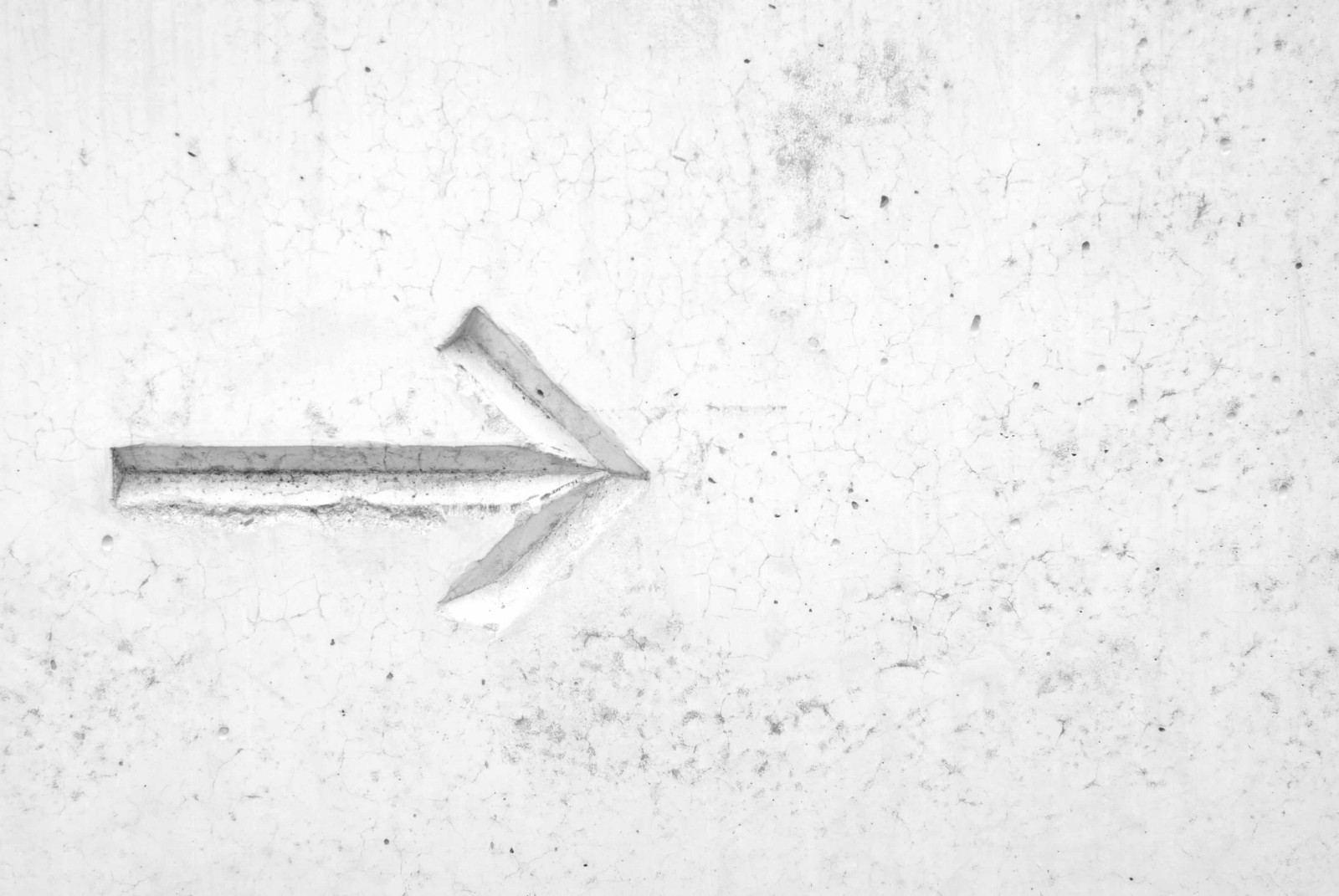 Arrow on a white wall pointing towards right